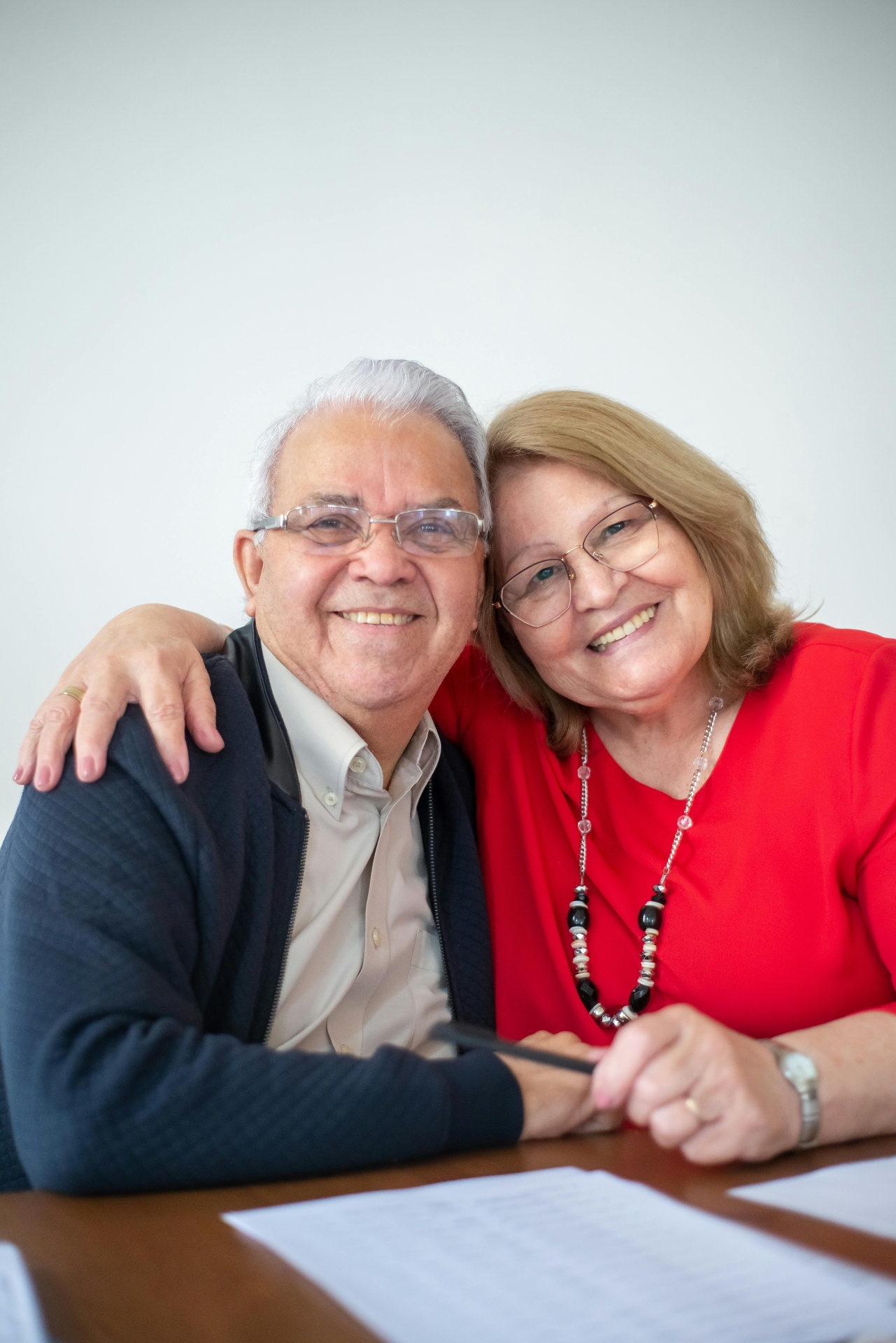 Casal de idosos sorrindo à mesa