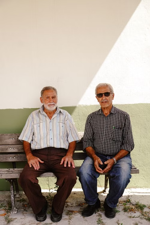 Dois senhores sentados em um banco